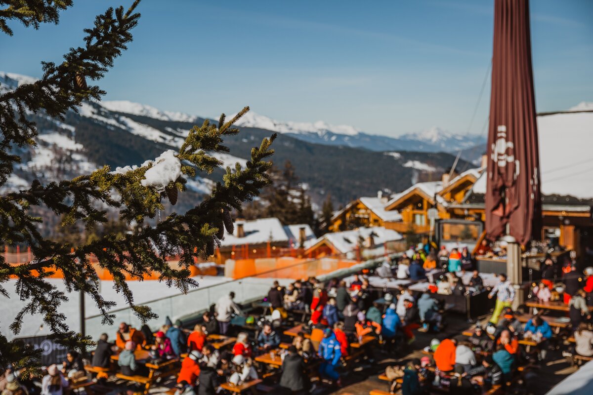A group of people are sitting at tables in the snow