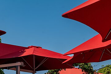 A row of red umbrellas against a blue sky