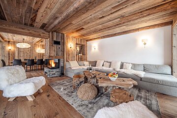 A living room with a large sectional couch and a fireplace