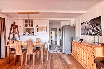 A dining room with a table and chairs and a refrigerator