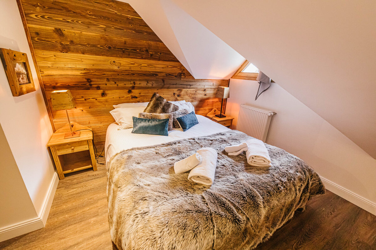 A bed with a fur blanket and pillows in a bedroom