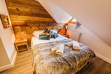 A bed with a fur blanket and pillows in a bedroom