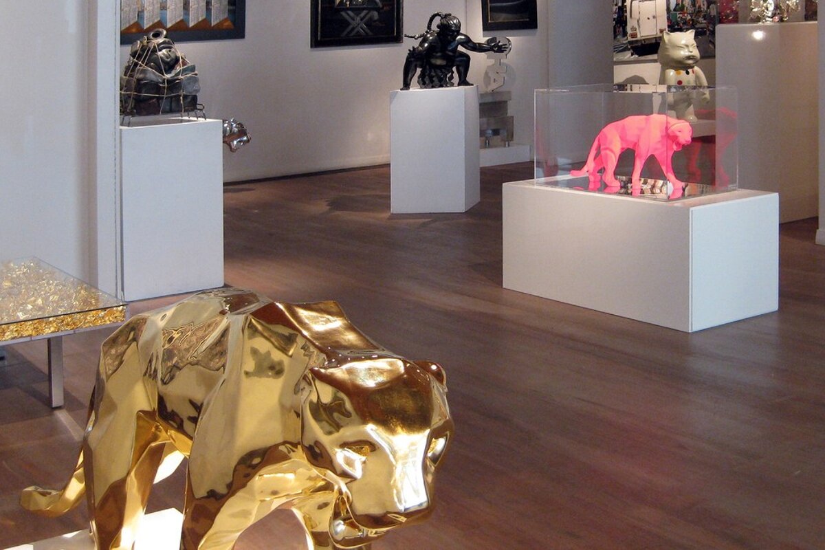 A display of sculptures including a gold elephant and a pink elephant