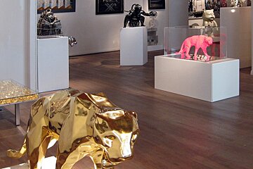 A display of sculptures including a gold elephant and a pink elephant