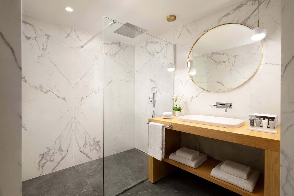 A bathroom with a walk in shower and a sink