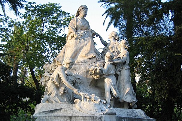 A sculpture of queen & servants in a park