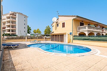A large house with a swimming pool in front of it