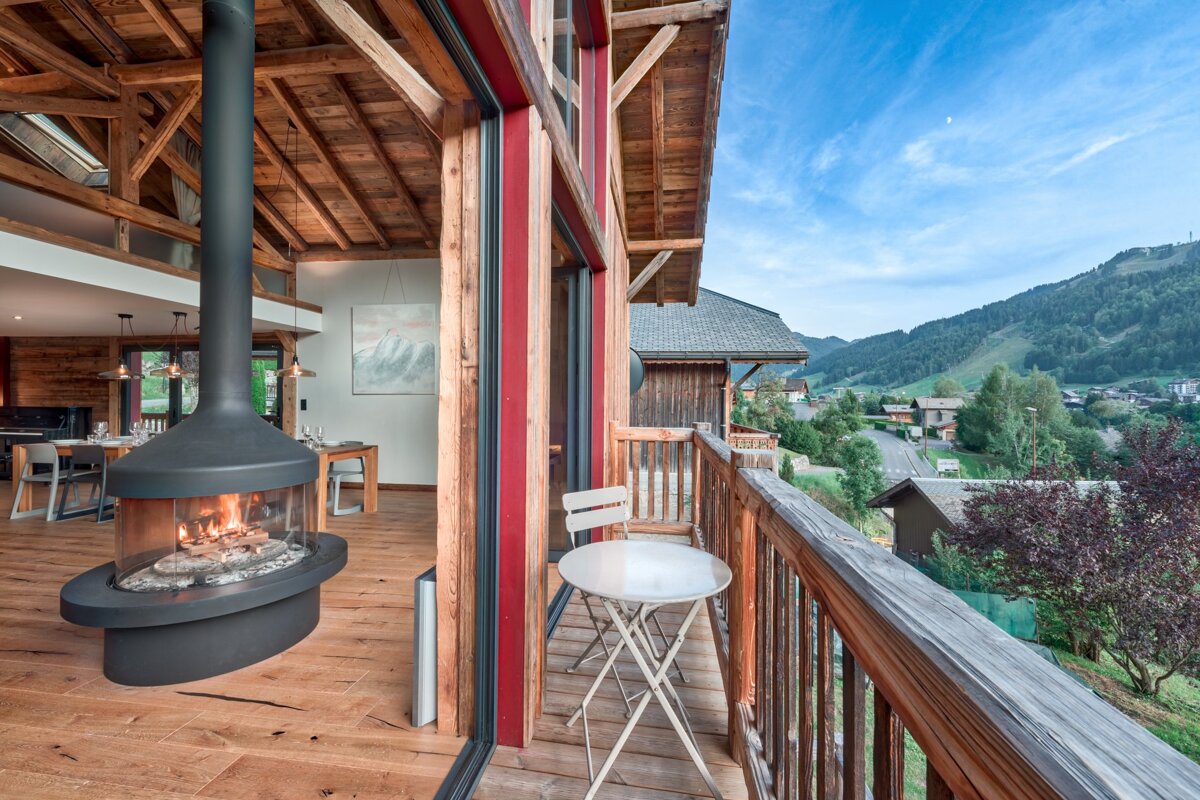 A balcony with a fireplace and a view of the mountains