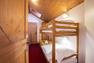 A bunk bed in a room with a wooden door