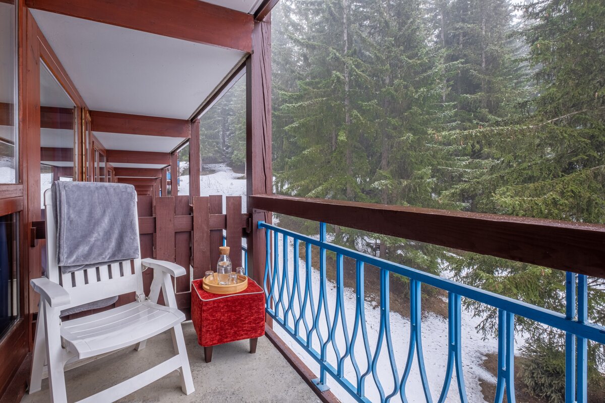 A balcony with a chair and a bottle on it