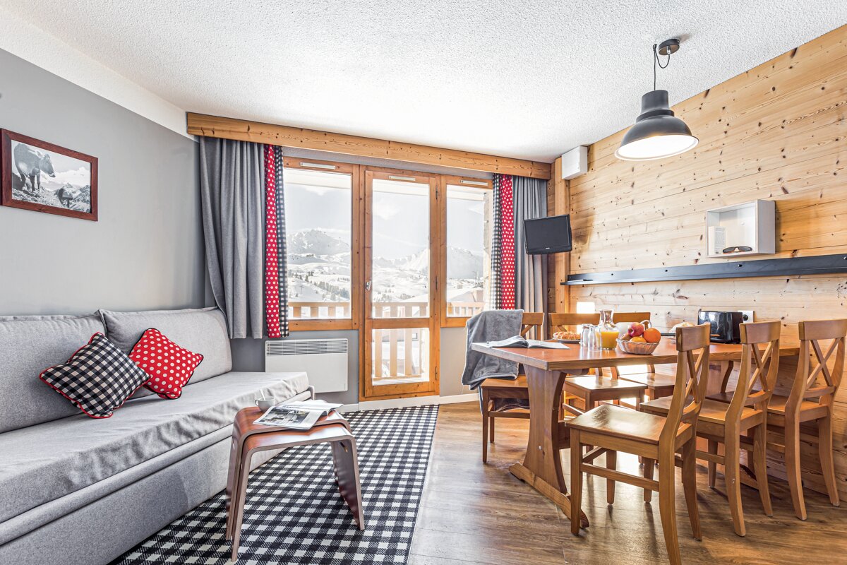 A living room with a couch a table and chairs