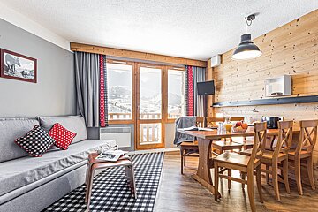 A living room with a couch a table and chairs