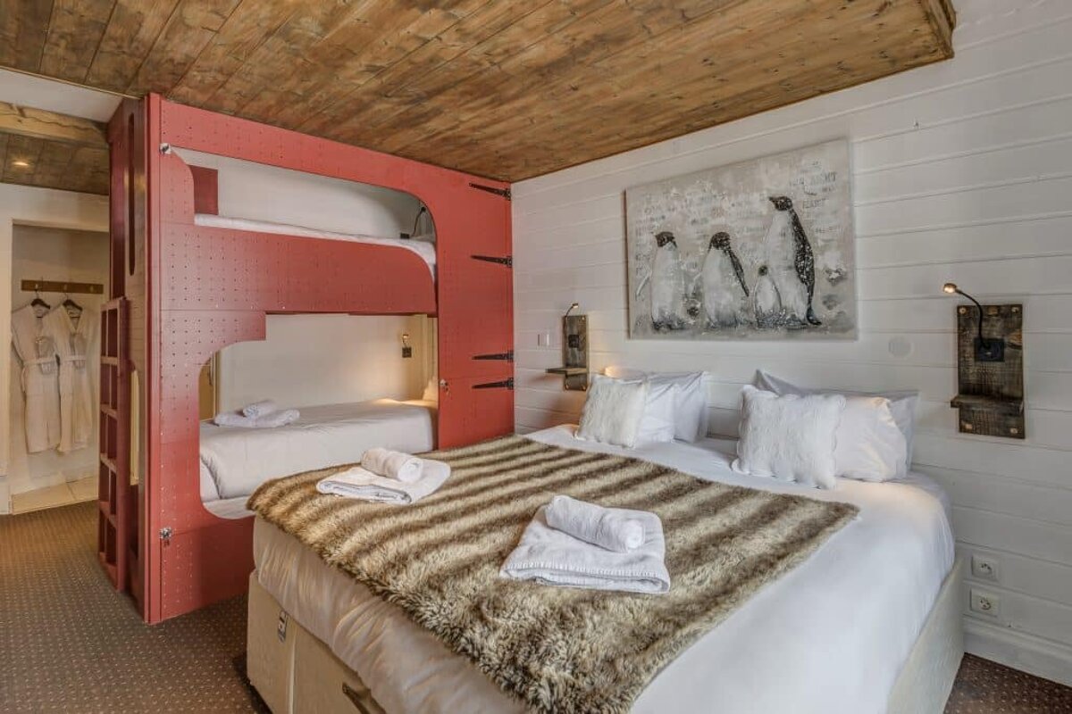 A bedroom with a bunk bed and a painting of penguins on the wall