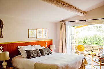 A bedroom with a large bed and a sliding glass door