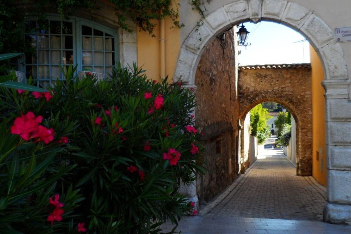 a stone archway over a cobbled street