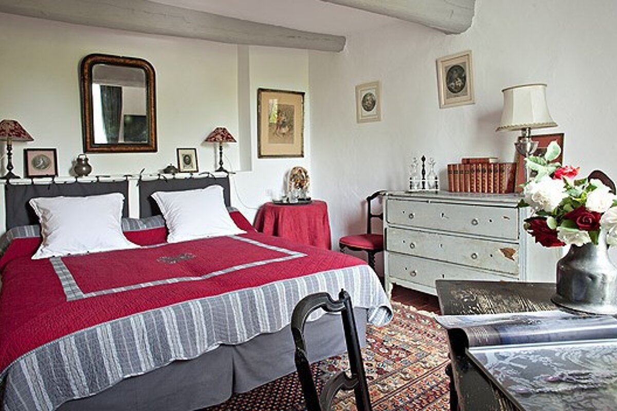 A bedroom with a large bed and a dresser