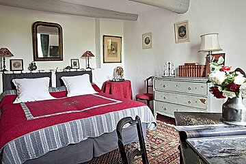 A bedroom with a large bed and a dresser