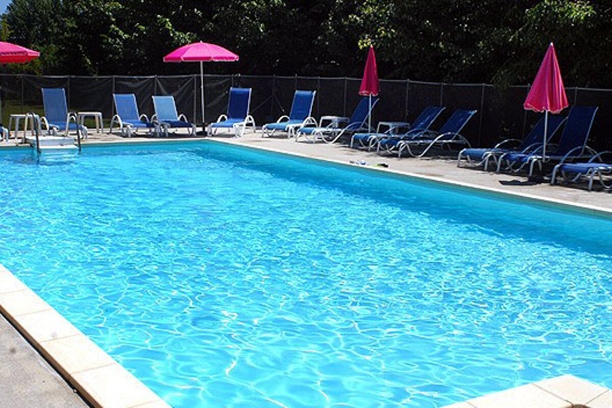A swimming pool with chairs and umbrellas around it