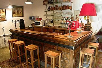 A large wooden bar with stools and a red lamp
