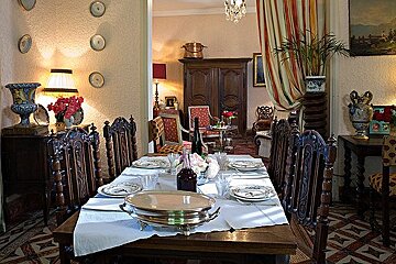 A dining room with a table and chairs and plates on it