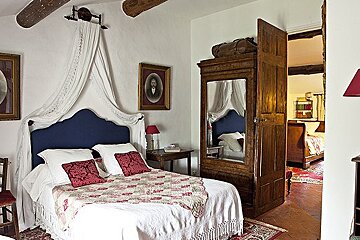 A bedroom with a canopy bed and a picture on the wall