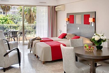 A hotel room with two beds and a table