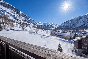 The sun is shining brightly over the snowy mountains