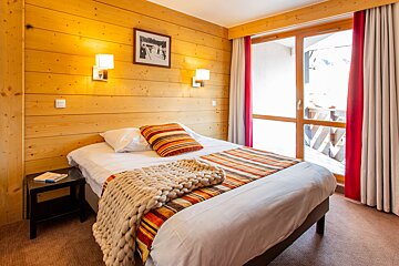 A bedroom with a bed and a picture on the wall