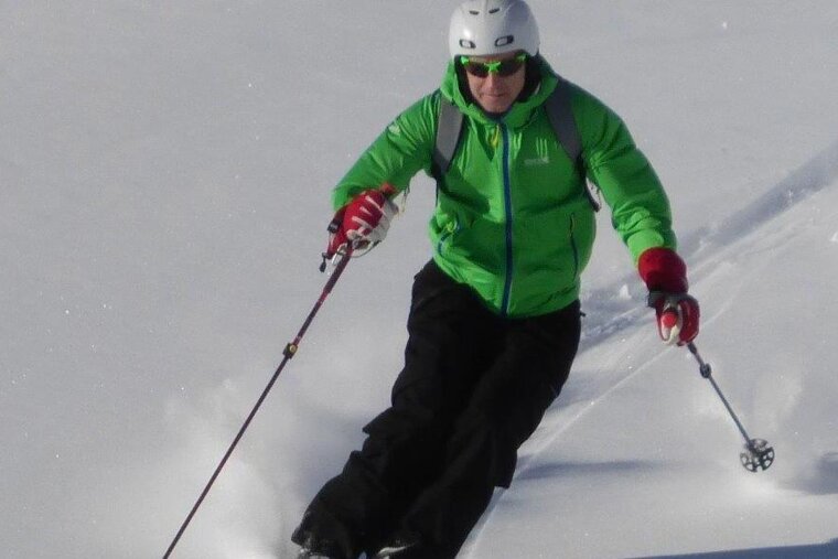 a skier in green jacket
