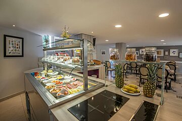 A buffet with pineapples bananas and jars of dried fruit