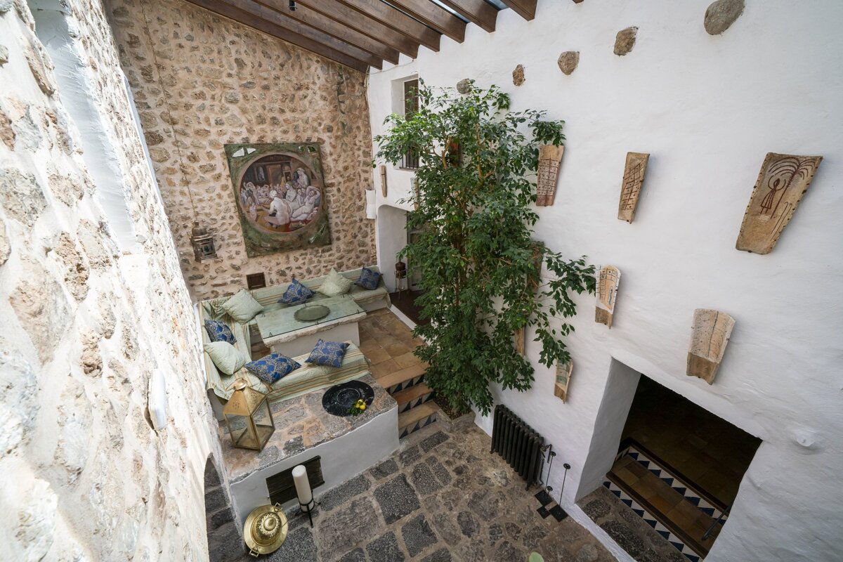 A room with a tree and a painting on the wall