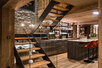 A staircase leading up to a kitchen with a glass railing