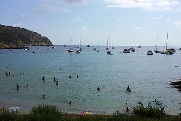 people swimming and boats in the sea