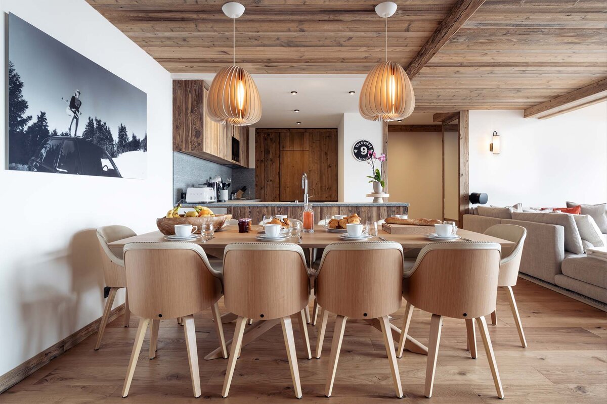 A dining room with a wooden table and chairs