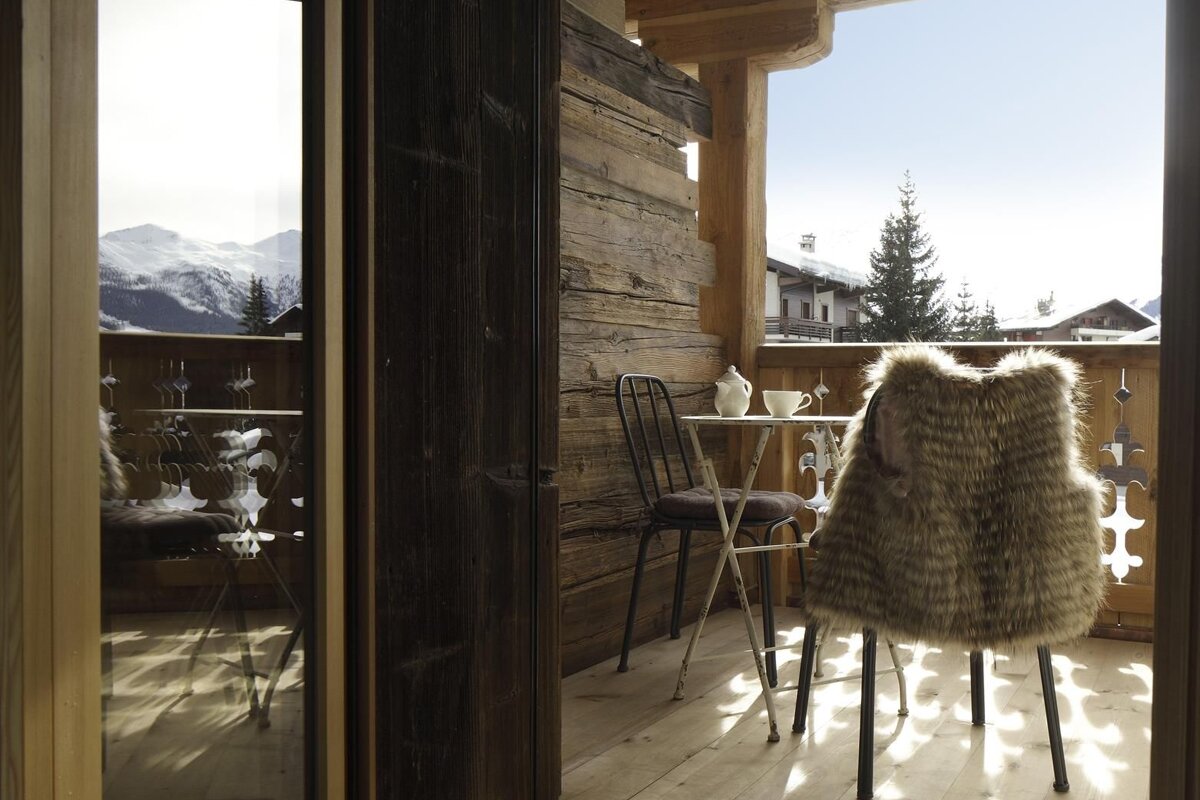 A fur vest sits on a chair on a balcony