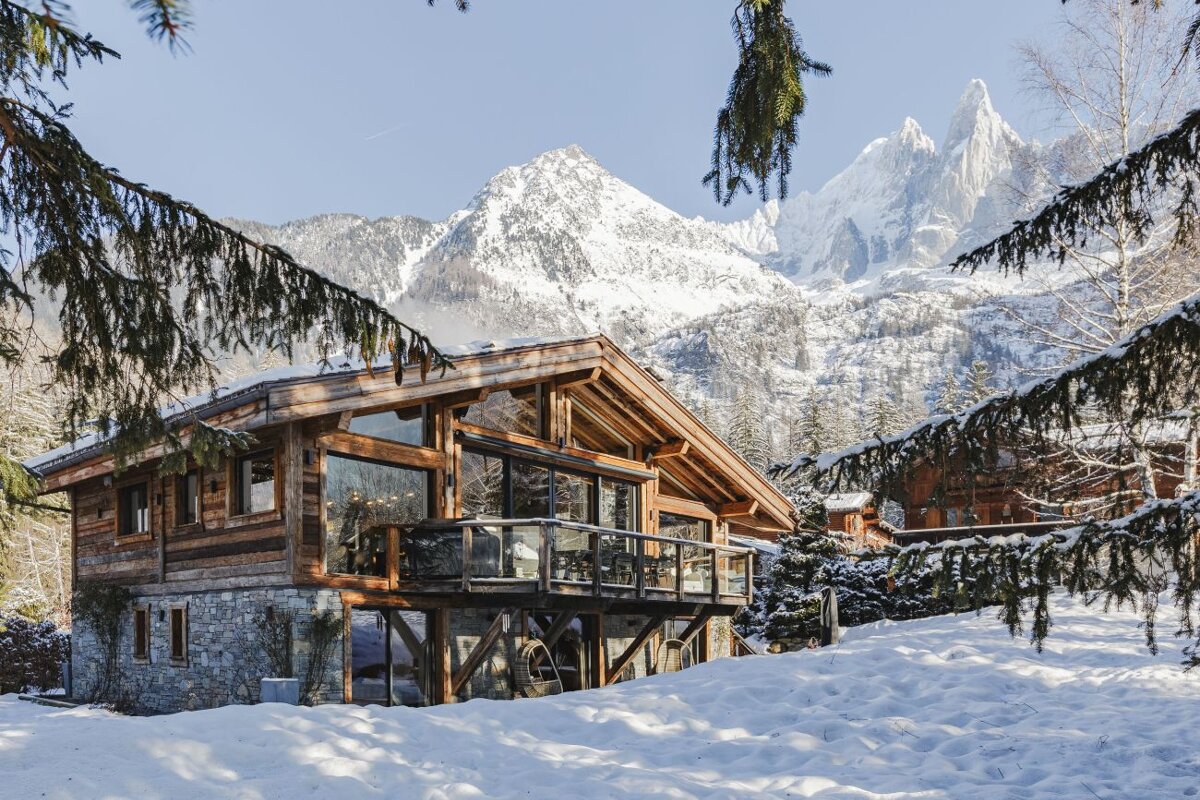 A cabin in the snow with mountains in the background