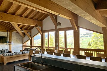 A kitchen with a sink and a dining table with a view of the mountains