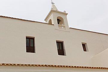 A white building with a cross on top of it