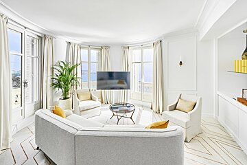 A living room with white furniture and a flat screen tv