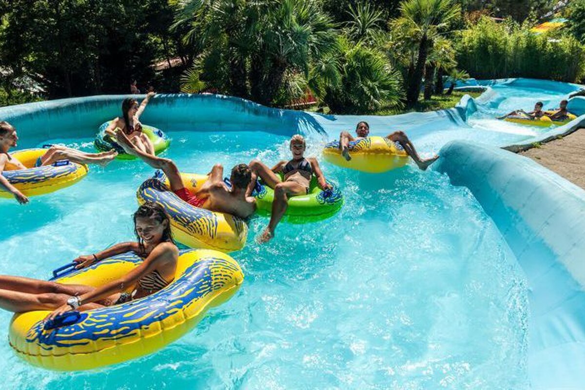 A group of people are riding rafts down a water slide at a water park