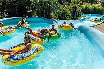 A group of people are riding rafts down a water slide at a water park