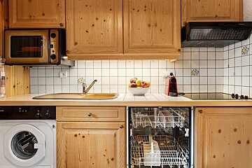 A kitchen with a washing machine and a dishwasher