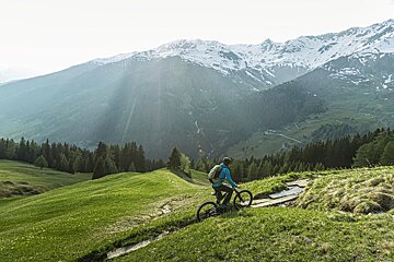 A person riding a bike on a trail in the mountains