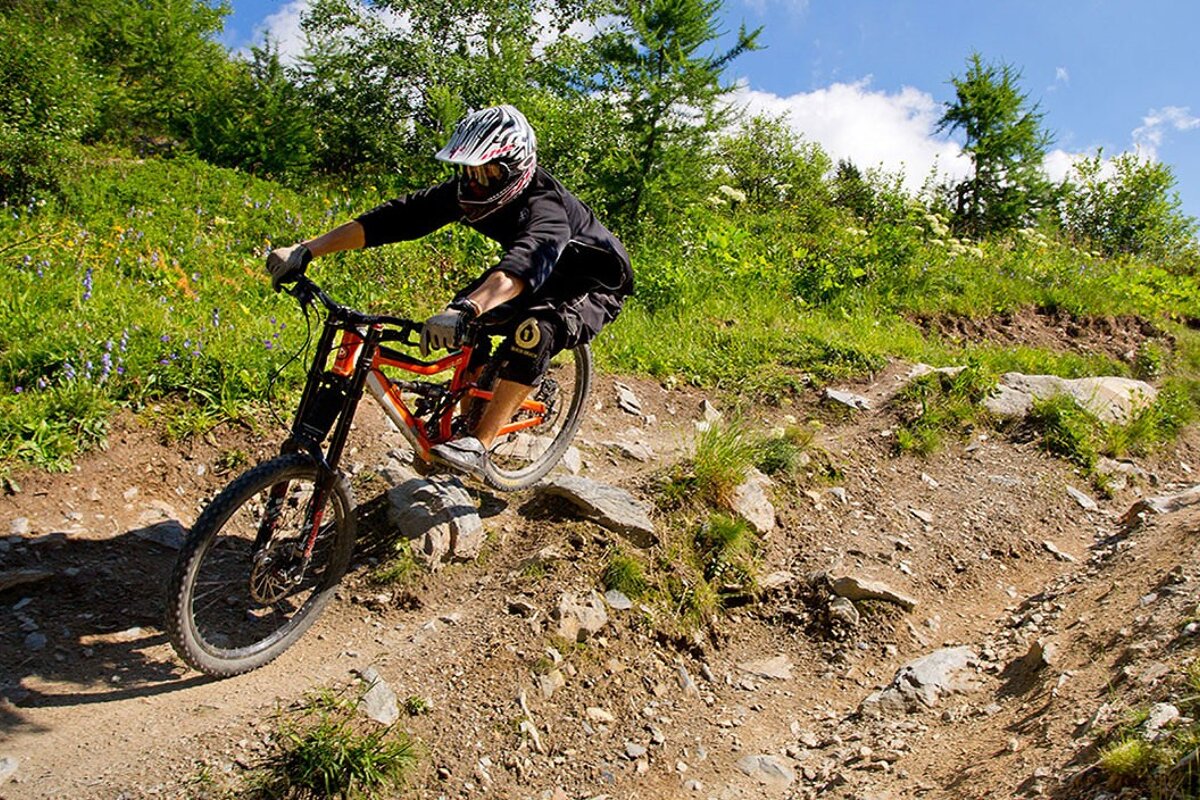 a mountain biker taking the rocky line on a trail