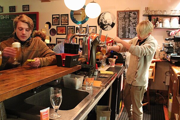 someone pouring drinks behind a bar