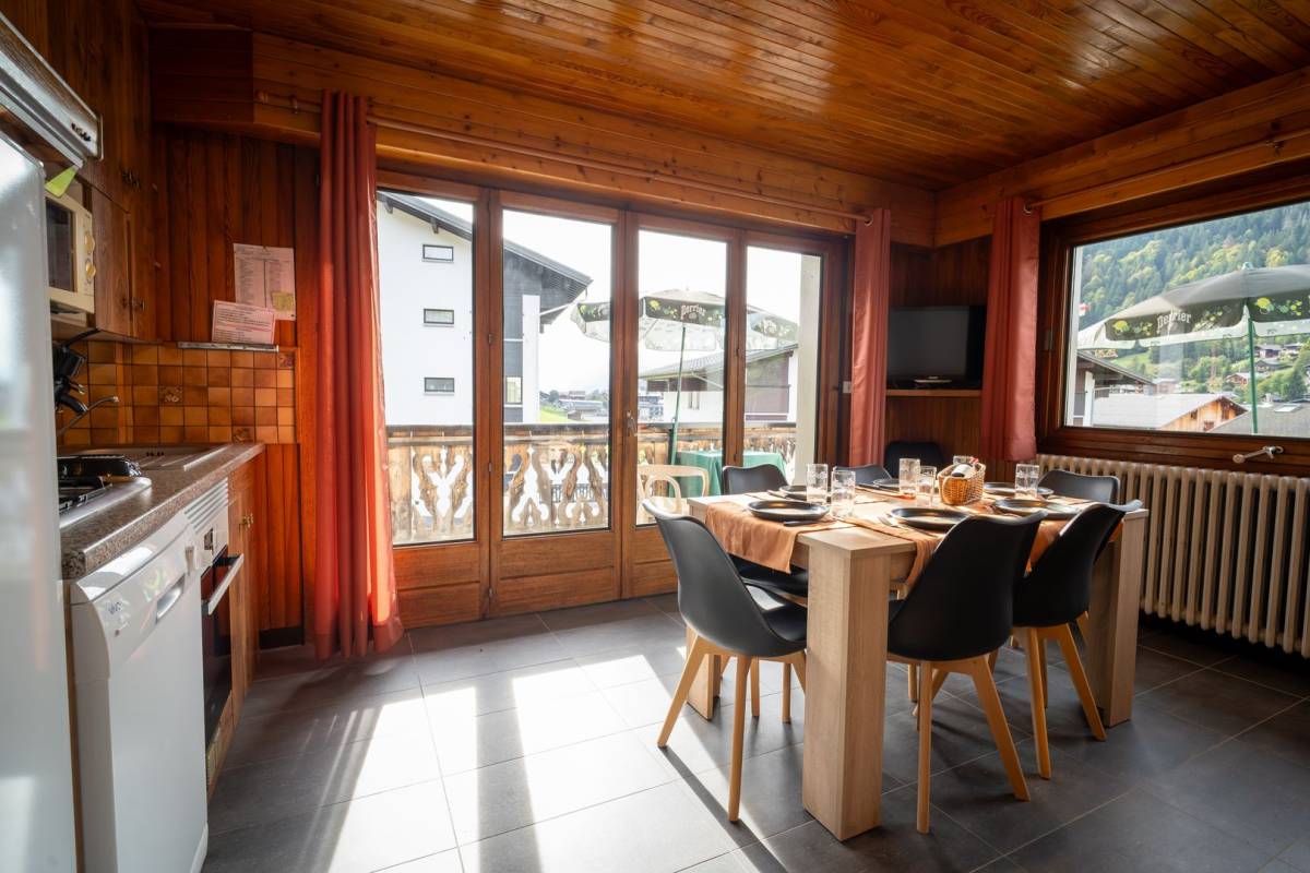 A kitchen with a table and chairs and a large window