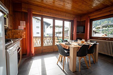 A kitchen with a table and chairs and a large window