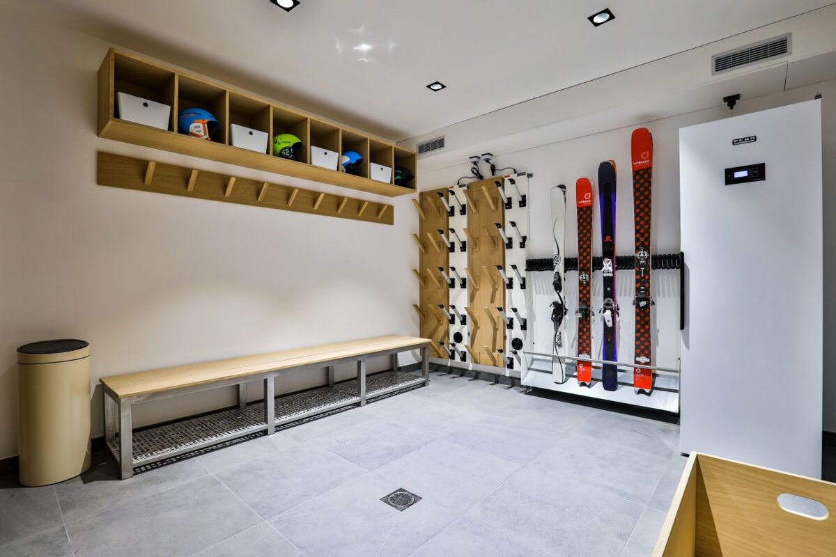 A locker room with skis and helmets hanging on the wall