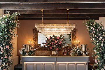 A bar with a chandelier and flowers on it
