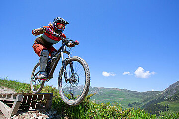 a female mountain biker jumping a ramp